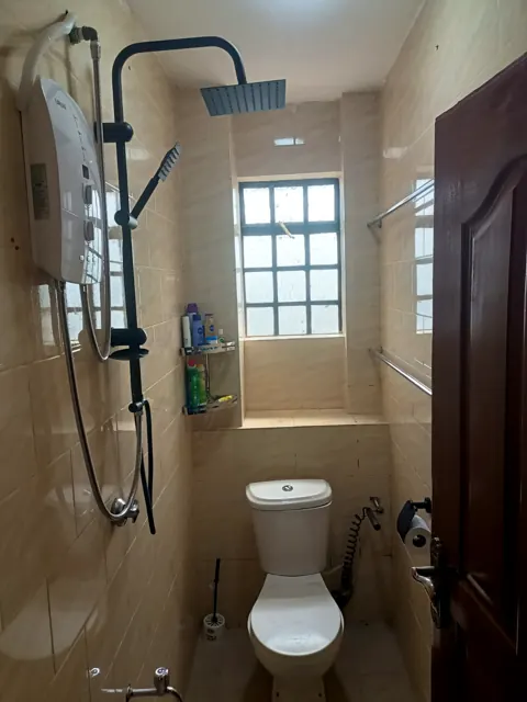 Tiled bathroom with rain shower, instant heater and towel rails