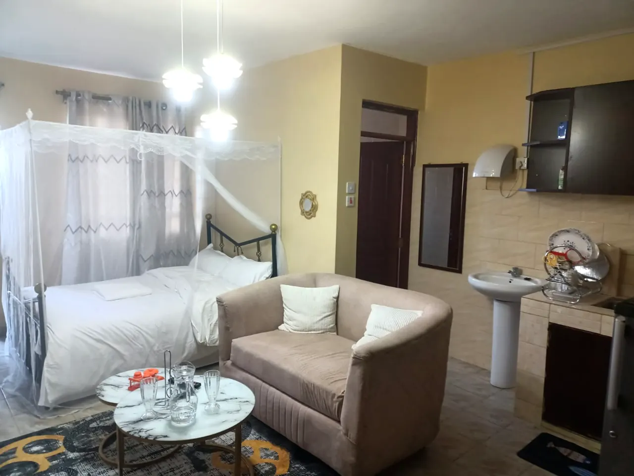 Sunlit suite with four-poster canopy bed, lounge sofa and kitchenette