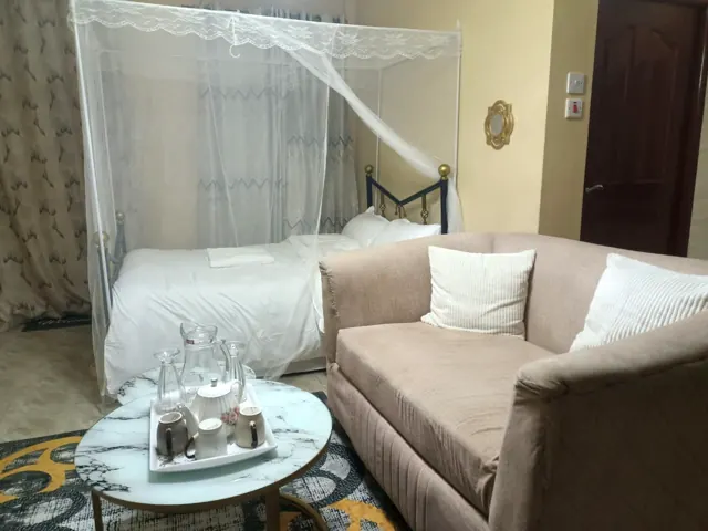 Evening view of lounge sofa, tea service and canopy bed
